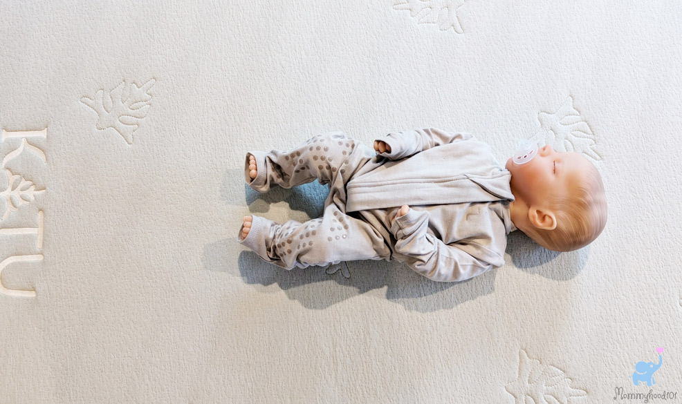 a baby sleeping on the katu crib mattress