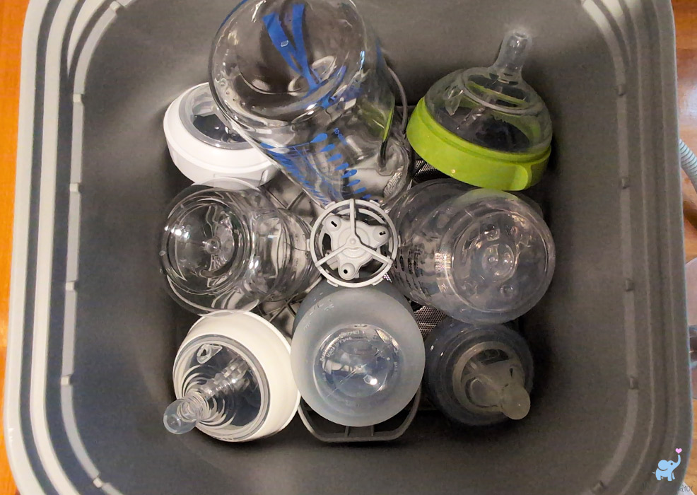 baby bottles and nipples packed into the lower rack of the momcozy bottle washer